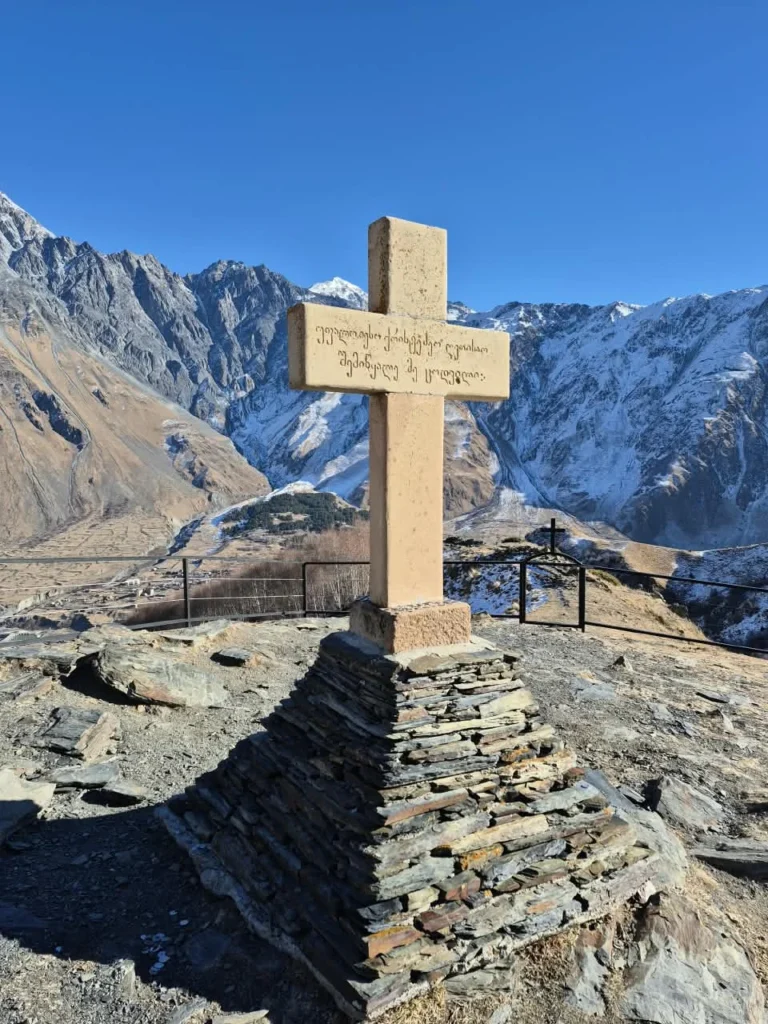 A stone cross at a mountain viewpoint near Kazbegi.